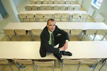 Jacek Sitting on a Table in a Classroom
