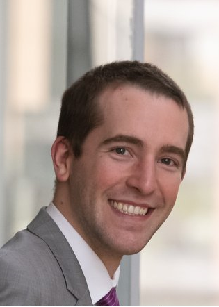 Headshot of Nick Seeman, a man with short brown hair and a friendly smile. 