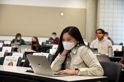 Undergraduate student at her laptop in a classroom